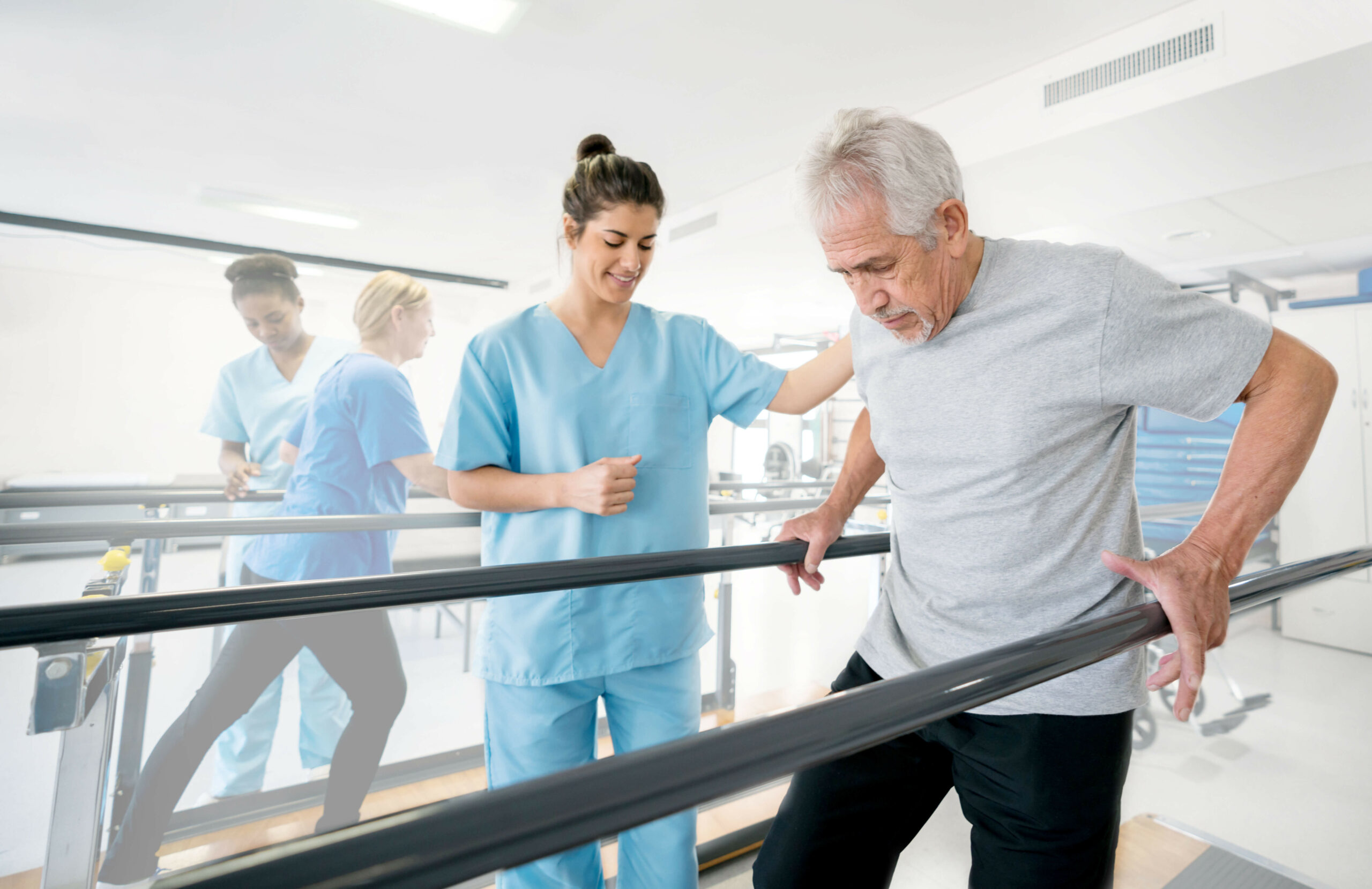Aide helping an older man with physical rehabilitation