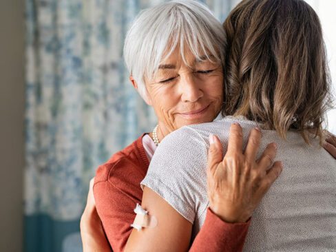 Older woman hugging another woman